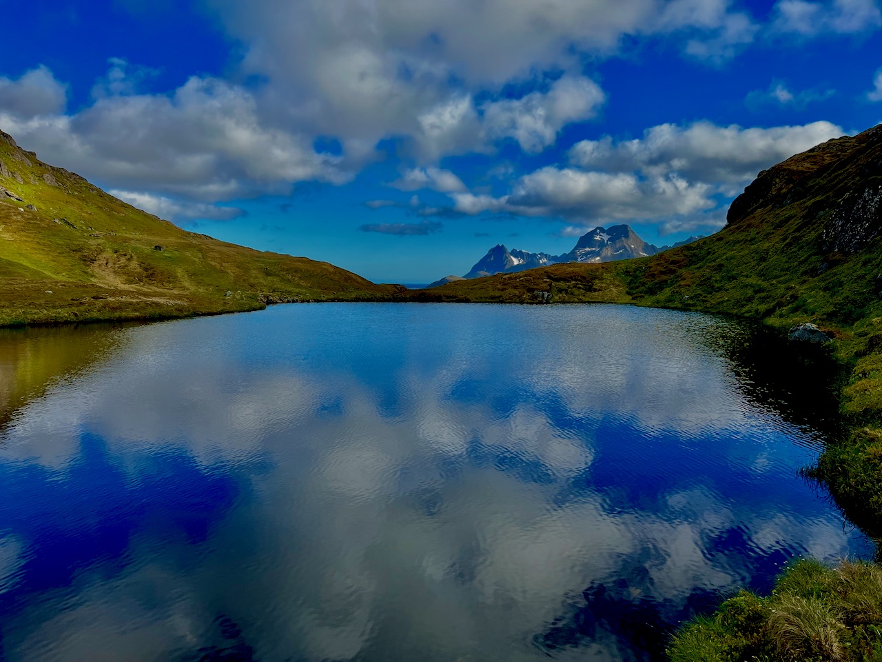 A mountain tarn in Norway, clouds mirrored in perfectly still water