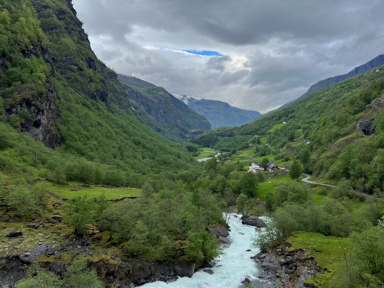 A glacial river running through a lush green Norwegian valley